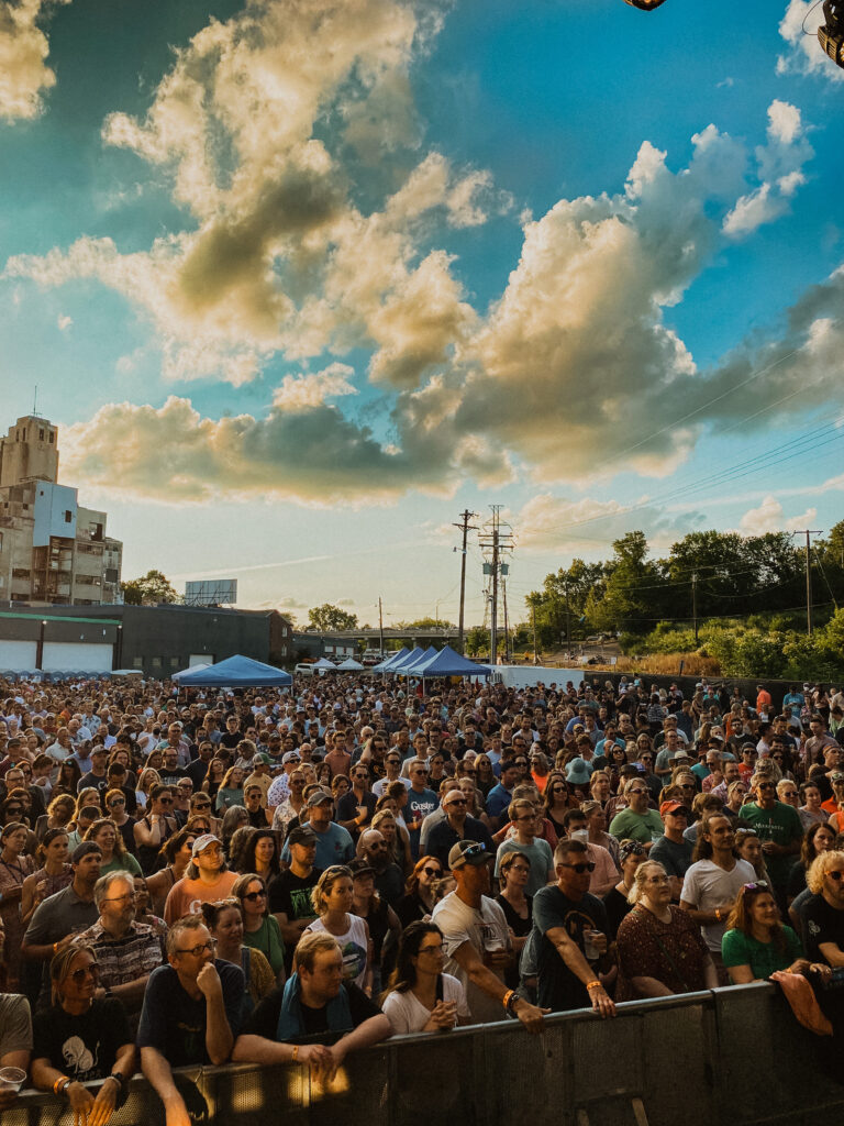 A crowd of fans gathered at a concert outdoors