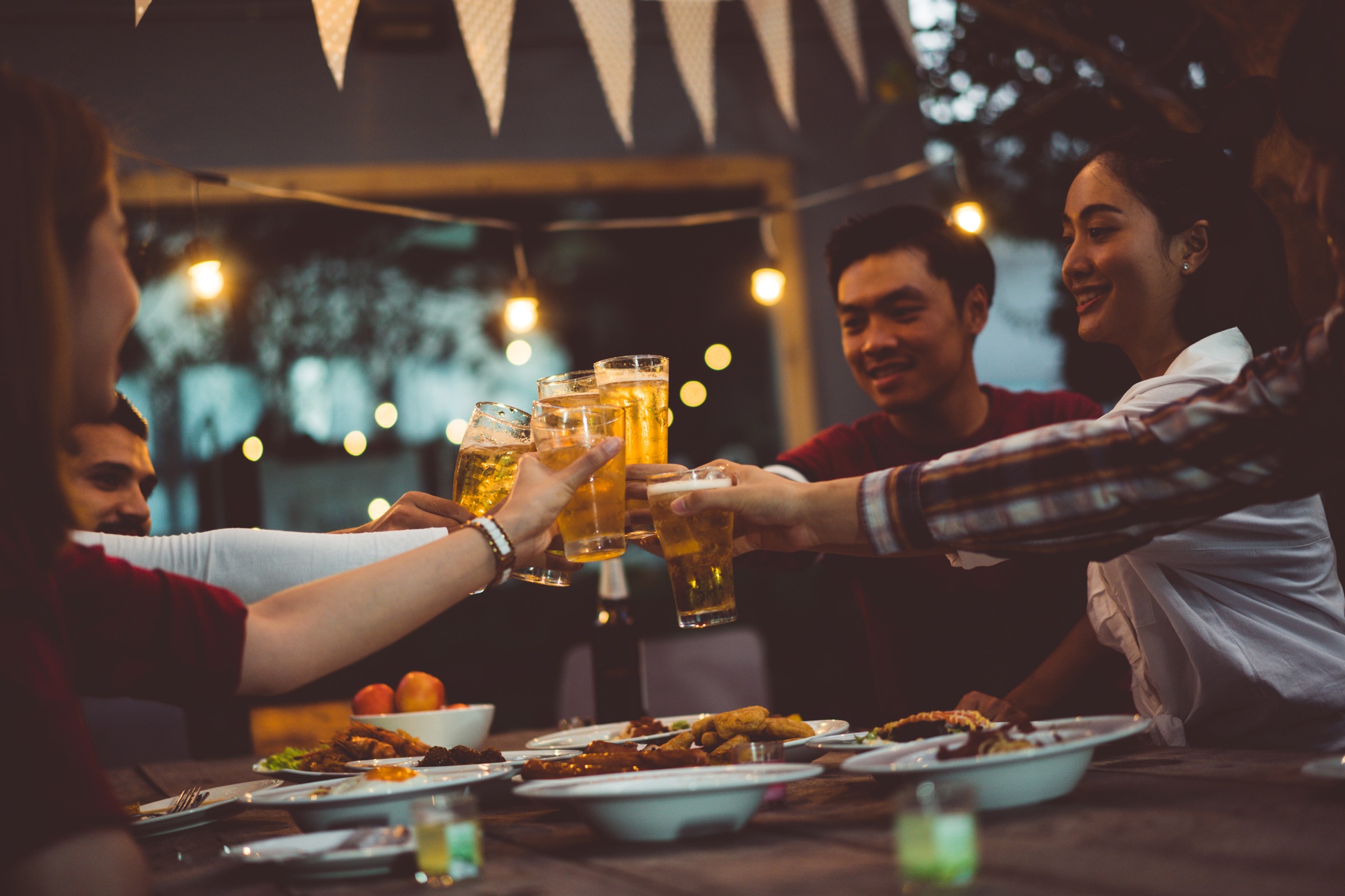 Group of friends toast outdoors over a dinner