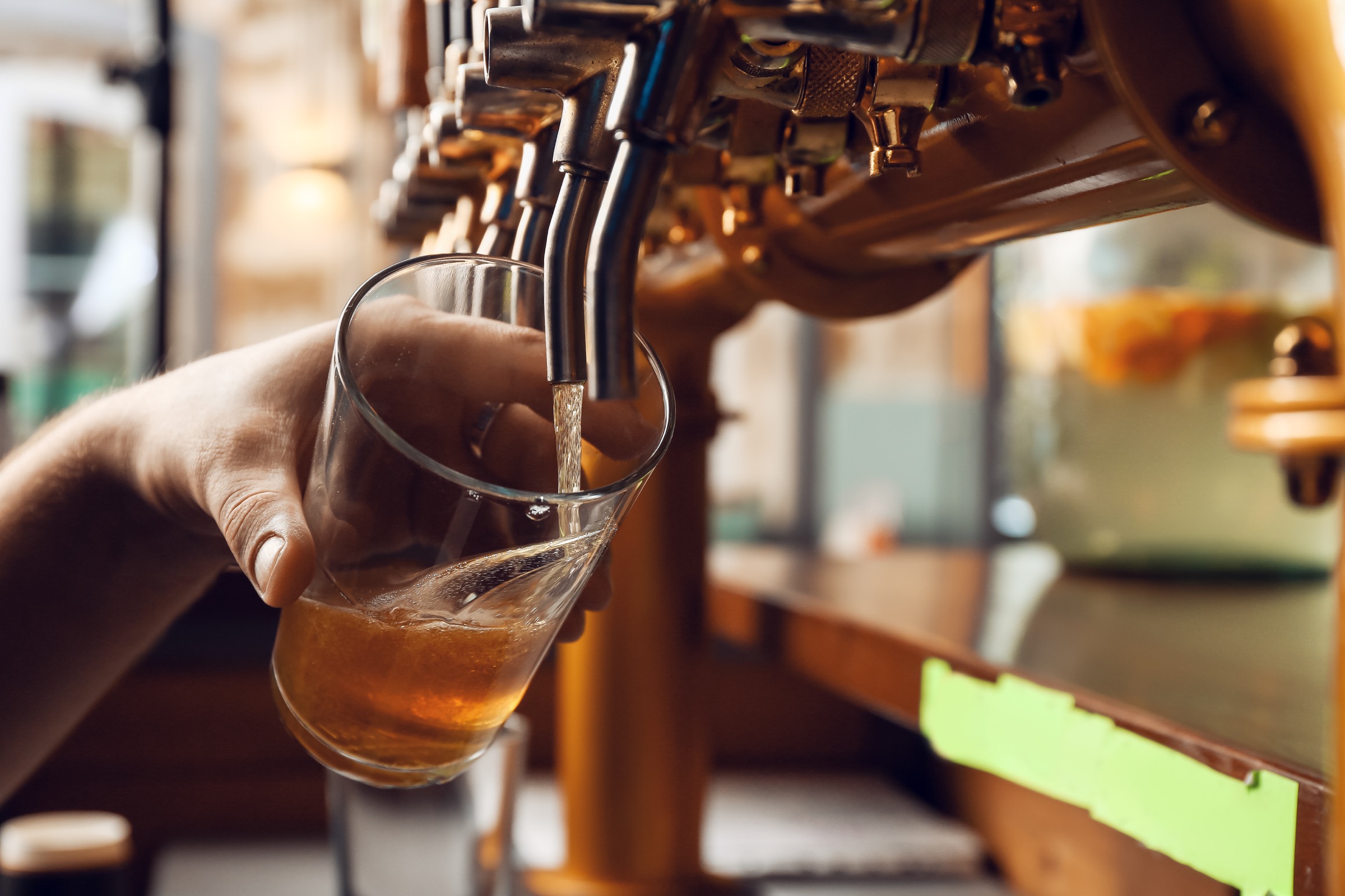 Close up view showing a tap pouring beer into a glass