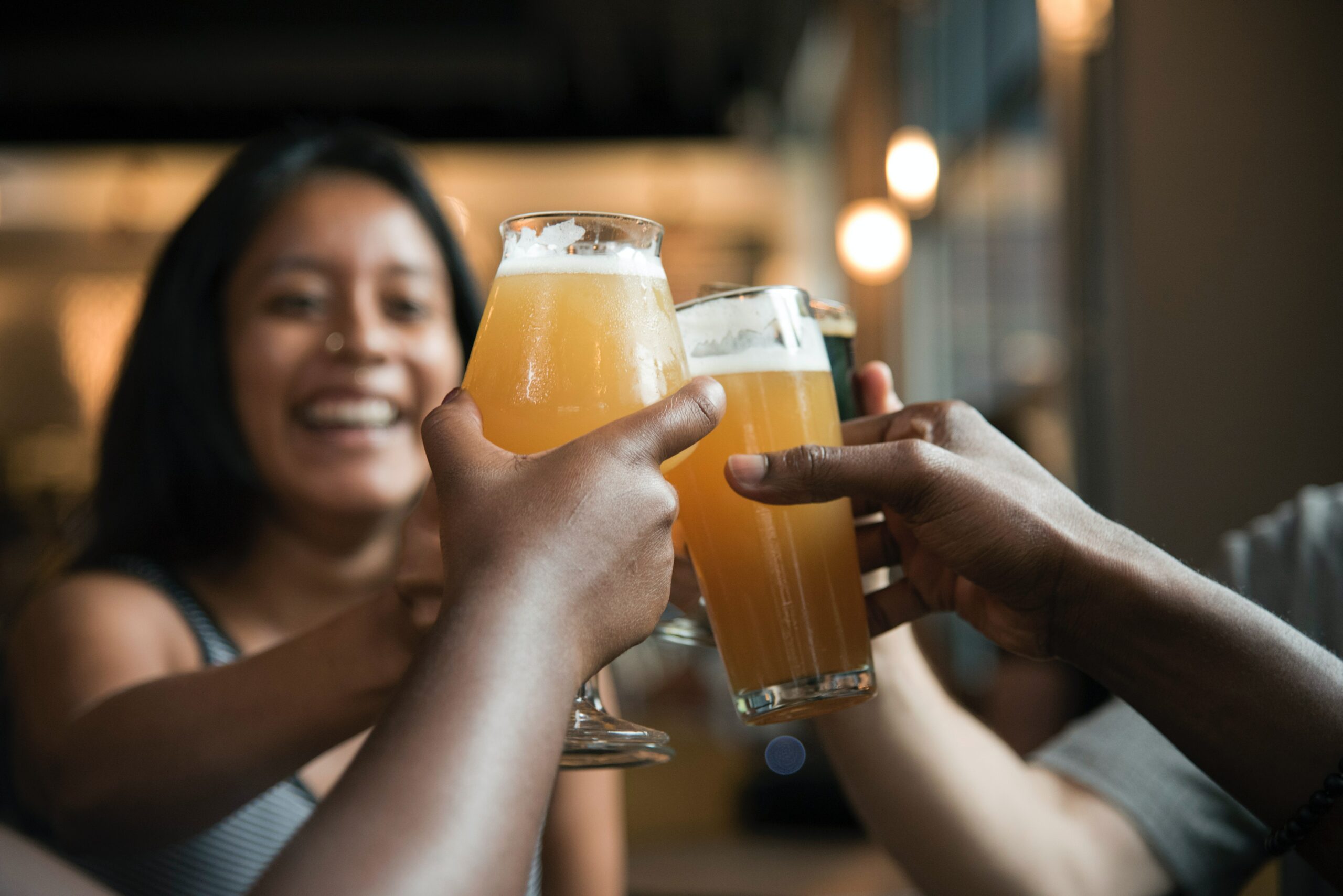 Group of friends raising a toast with beer in each glass